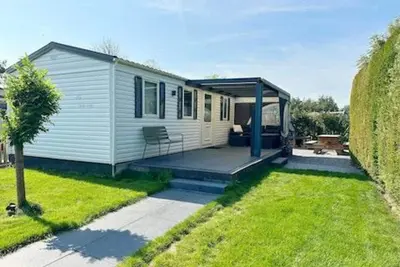Image de This great compact chalet has three bedrooms and a covered terrace. It has its own passage to the playground. The chalet is therefore ideal for a family with (small) children!