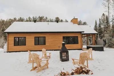Image de Chalet en forêt avec spa et foyer extérieur