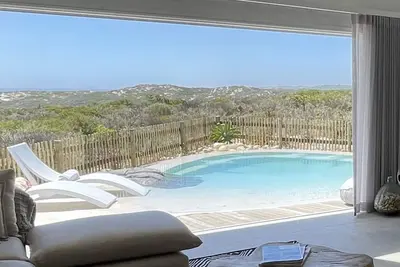Image de Tranquil haven: home in nature's embrace, where ocean and dunes unite.