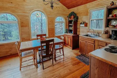 Image de Beautiful, authentic log cabin with acres of land, fishing pond, and hot tub.
