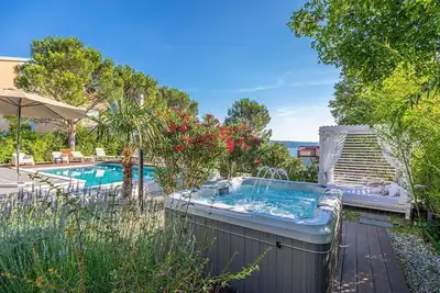 Image de Villa en bord de mer avec piscine privée, jacuzzi et vue sur la mer.