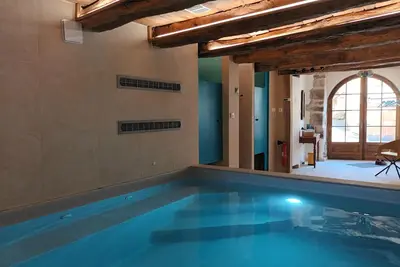 Image de Maison de vacances 'La Clé Des Sens' vue sur les montagnes, terrasse privée et piscine intérieure.
