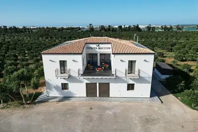 Image de Tenuta Macconi Country Rooms, nestled in a lush citrus grove near the sea.