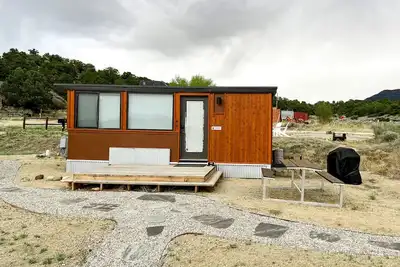 Image de Oxford is a one-level 1-2 person Tiny Home with full bathroom, fridge, induction cooktop, microwave, Ac/heat, dryer/washer combo, and beautiful mountain views!