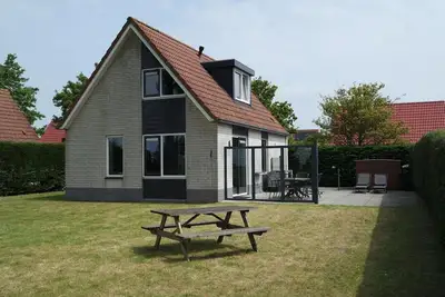 Image de Schoneveld 184 is a holiday home of the type \"Stern\". The holiday home is quietly situated on the edge of holiday park Schoneveld and has a view over nature reserve \"Waterdunen\".