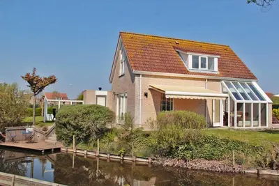 Image de Breskens Vakanties - Strandpark Scheldeveste Zwin no. 12. A detached 6-person bungalow with approx. 102m2 of living comfort and a lovely garden right by the water.