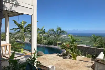Image de appartement avec grande piscine dans un jardin tropical