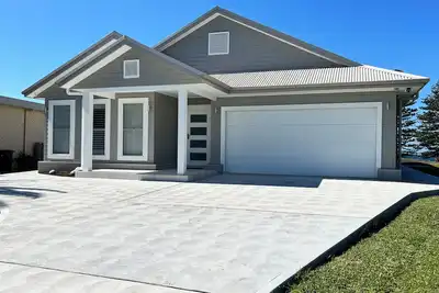 Image de The Ocean’s Edge is a contemporary coastal home with stunning beach views.