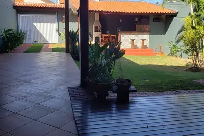 Image de Casa com ares de campo na cidade. Deck com redes e bancos, jardim e quiosque.