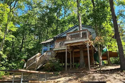 Image de 2-story treehouse with a cargo net connecting the upstairs lofts, a large balcony with a slide to the ground level, sleeps 10.