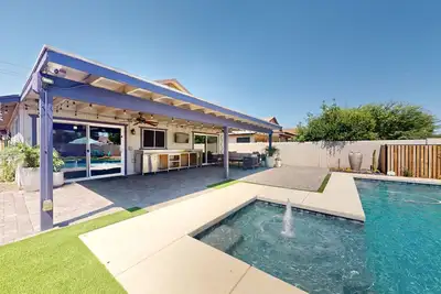 Modern home featuring backyard oasis with private pool, grill, corn hole