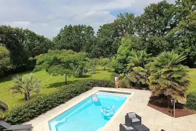 Image de Maison chaleureuse avec piscine dans parc paysager