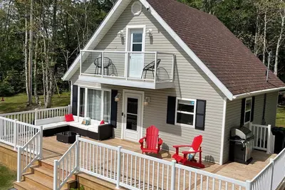 Image de Cozy cabin style cottage tucked into the woods with a view of the water.