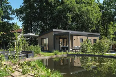 Image de Enjoy a luxurious holiday home for 4 people in the wooded surroundings of the Veluwe, complete with modern amenities and air conditioning for optimal comfort. Additionally, you can fully unwind in the delightful private hot tub, perfect for relaxing