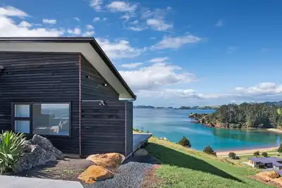 Coastal Gem. Great sea views, decks for outdoor living and safe swimming beach.