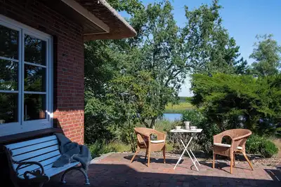 Image de Right on the water: large thatched house with garden and fireplace