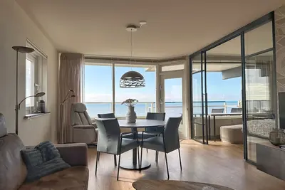 Image de New In Our Offer! The corner apartment Sterflat221 is located on the 9th floor, on the sunny south-west side. It offers you a wonderful view of the beach, North Sea, village and dunes. Thanks to the altitude and the perfect position of the sun, you almos