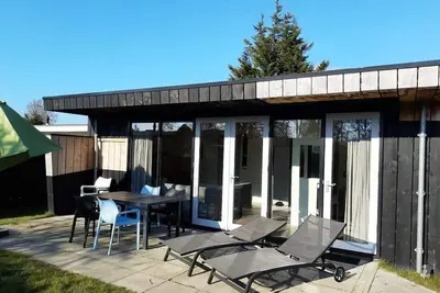 Image de Contemporary, completely renovated 5-person bungalow, furnished according to the latest trends near the beach, sea, woods and dunes. Free WiFi and pet welcome.