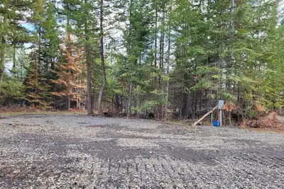 Image de Large Rv site with full hookups, surrounded by trees and nature.