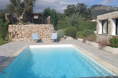 Image de Ancienne maison corse rénovée avec piscine et bel espace extérieur.