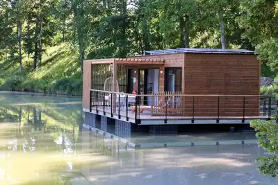 Image de House Boat 'L'Õdacieuse : Écolodge Flottant Et Unique' avec vue sur lac, terrasse et climatisation