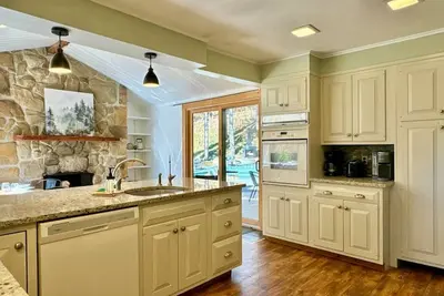 Image de Nestled among towering evergreen trees, this charming home offers a tranquil retreat
