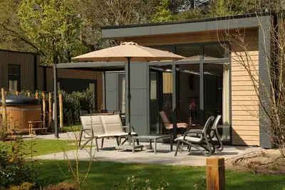 Image de Stylish 6-person home with three bedrooms, a modern kitchen, air conditioning, and a cozy outdoor space with a luxury pergola and private hot tub. Enjoy comfort and nature in the Veluwe.