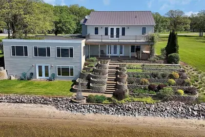 Image de Gather at this spacious 5-bedroom lake home with 277' sandy beach, private dock