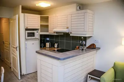 Image de Superficie d'environ 50 m². Niveau 0 : Séjour avec canapé-lit. Cuisine avec cafetière, grille-pain