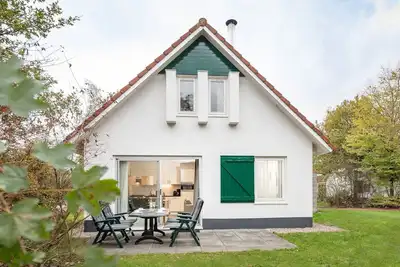 Image de Maison restylée avec cheminée, entourée de verdure