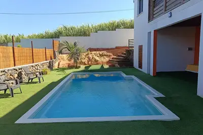 Image de Maison créole lumineuse avec Piscine paisible & vue sur la côte sauvage