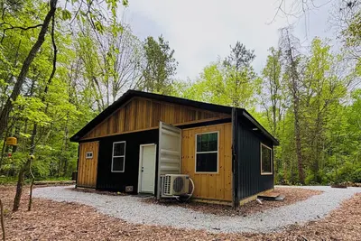 Image de Beehive shipping container cabin surrounded by nature and a pond