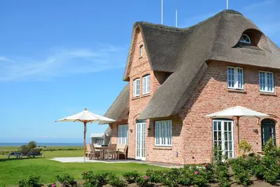 Image de New building under thatch with an unobstructed view of the water.