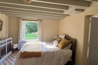 Maison de campagne dans une clairière entourée  d’une forêt de chênes.
