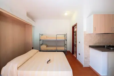 Image de Logement dans un village de vacances 'Monolocale Con Giardino' avec piscine partagée