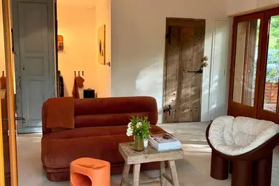 Image de Grange rénovée dans les arbres avec terrasse sur pilotis entourée de végétation