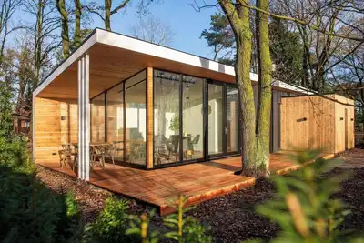 Image de Stylish forest cottage with private sauna and hot tub, surrounded by greenery. Ideal for couples or families seeking peace and wellness.