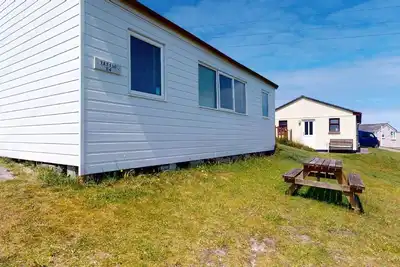 Image de A traditional beach chalet vibe, and outdoor seating with views toward St. Ives Bay