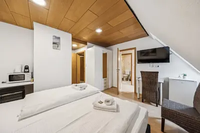 Image de Comfortable room with a double and single bed, private bathroom, flat-screen Tv, fridge, microwave, coffee machine, and cozy seating area. Ideal for small families or friends traveling together.