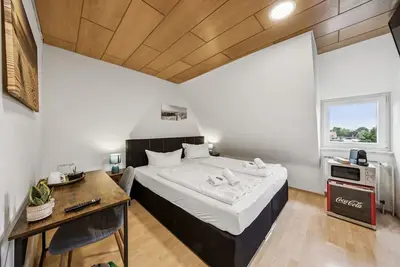 Image de Cozy double room, flat-screen Tv, and modern bathroom with shower. Ideal for couples and short stays – enjoy a relaxed atmosphere with warm wood accents and coastal charm.