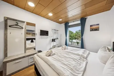 Image de Cozy double room, flat-screen Tv, and modern bathroom with shower. Ideal for couples and short stays – enjoy a relaxed atmosphere with warm wood accents and coastal charm.