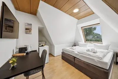 Image de Cozy double room, flat-screen Tv, and modern bathroom with shower. Ideal for couples and short stays – enjoy a relaxed atmosphere with warm wood accents and coastal charm.