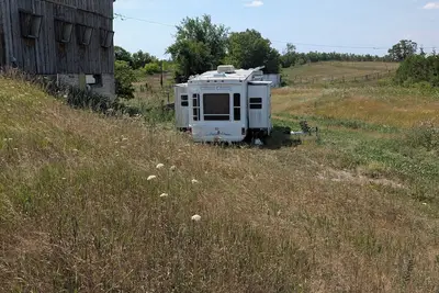 Image de Serenity Lane Farm Stay: a trailer next to a barn full of farm animals