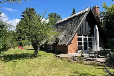 Image de Charmerende sommerhus med stråtag tæt ved vandet