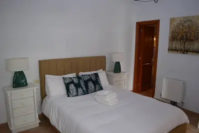 Image de This is a double room with a double bed. It has an en-suite bathroom. The window in the room looks out into the hallway.