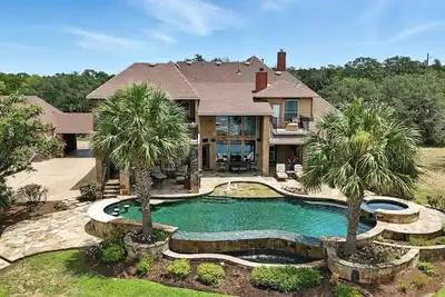 Image de Experience luxury on Lake Travis! Enjoy stunning lake views, a private pool, spa, fire pit, and plenty of space for the whole crew. This gated retreat sleeps 17+ and features a chef’s kitchen, bar, media room, game room, dedicated office, playscape,