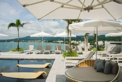 Image de Retraite Élégante en Bord de Mer avec Piscines à Débordement et Jeux