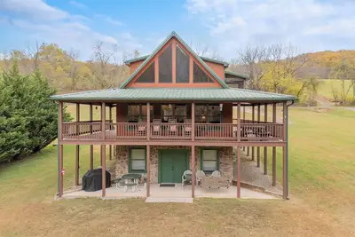 Image de Sunny riverside cabin with loft views, big deck, game room, porches, and open lawn.