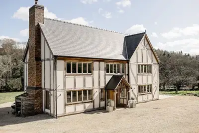 Image de A luxurious riverside cottage with stunning views, a hot tub, and fishing access.