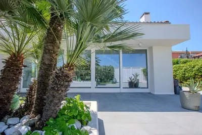 Image de Élégante villa en bord de mer avec jacuzzi, jardin et terrasse panoramique.
